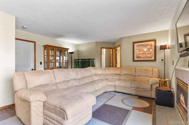 living area featuring a textured ceiling and a tiled fireplace