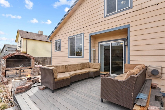 wooden deck featuring an outdoor living space with a fire pit and fence