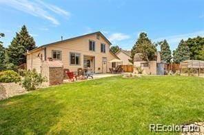 back of house with a yard and a patio area