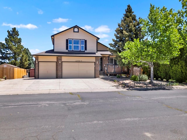 2957 W Rowland Ave, Littleton, CO 80120 - view of front facade with a garage, brick siding, and concrete driveway