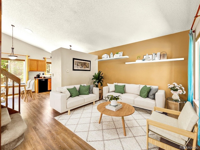 2957 W Rowland Ave, Littleton, CO 80120 - living area featuring a textured ceiling, light wood-style flooring, vaulted ceiling, and stairway