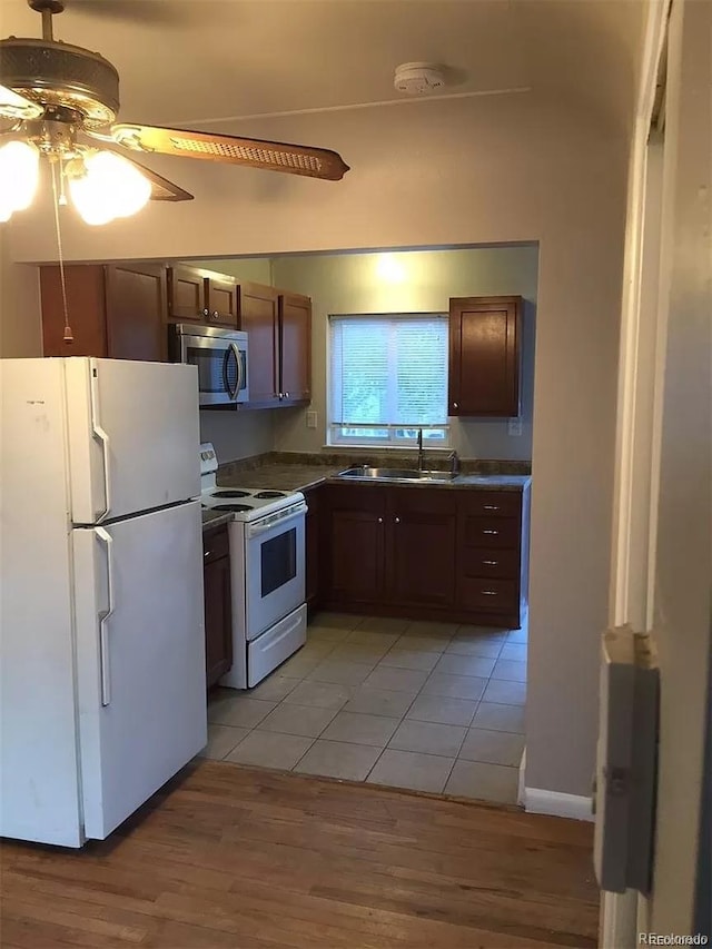 kitchen with ceiling fan, white appliances, sink, and light hardwood / wood-style flooring