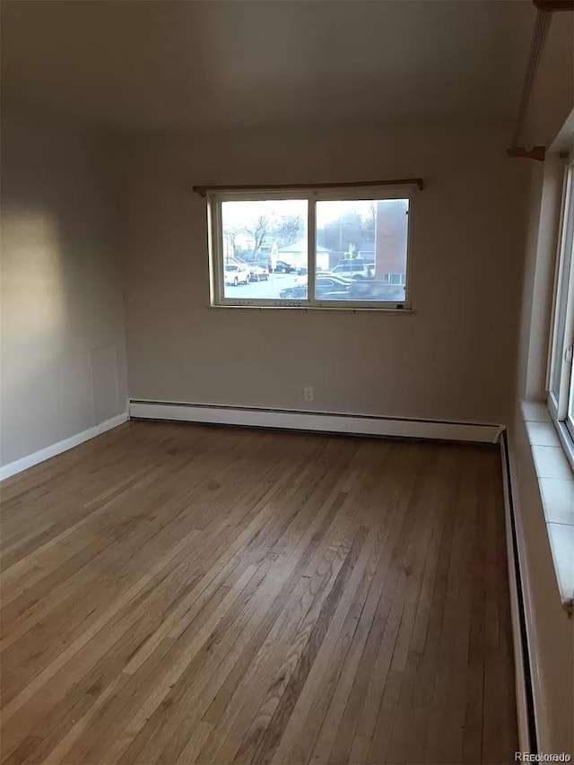 spare room featuring light wood-type flooring and a baseboard radiator