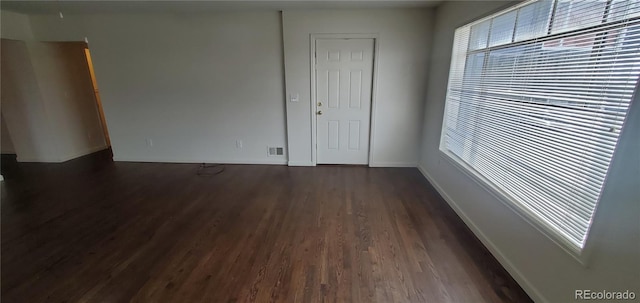 spare room with dark hardwood / wood-style flooring