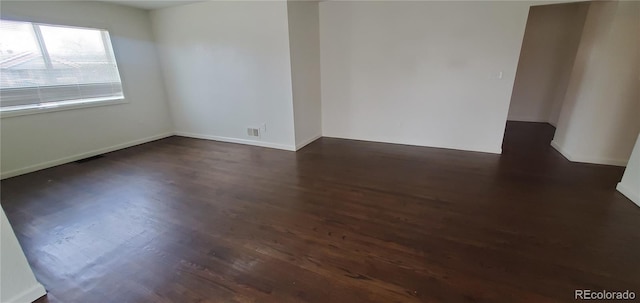 spare room featuring dark wood-type flooring