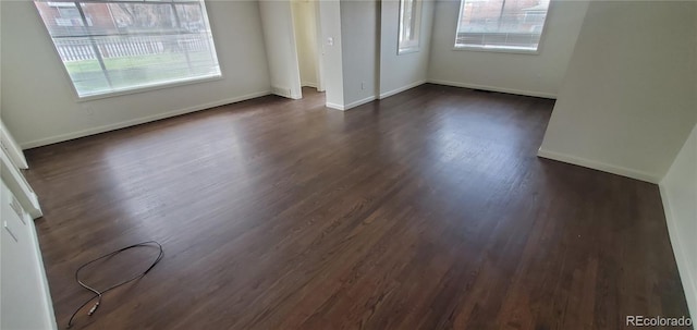 empty room with dark hardwood / wood-style flooring