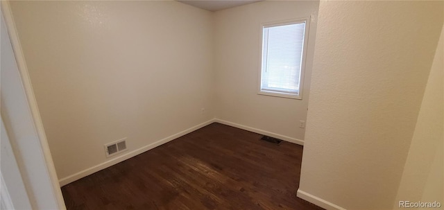 spare room featuring dark hardwood / wood-style flooring