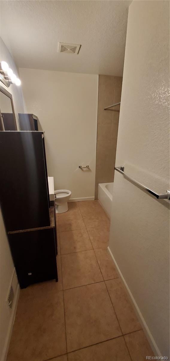 full bathroom with tile patterned floors, vanity, toilet, and tiled shower / bath combo