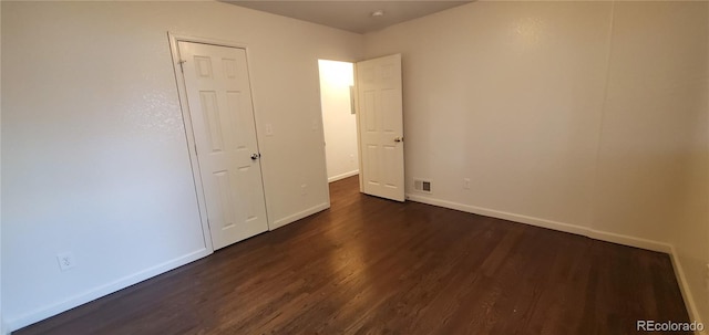 unfurnished bedroom with dark hardwood / wood-style flooring