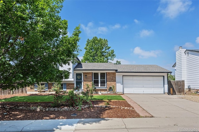 1153 S Biscay St, Aurora, CO 80017 - split level home featuring brick siding, an attached garage, and driveway