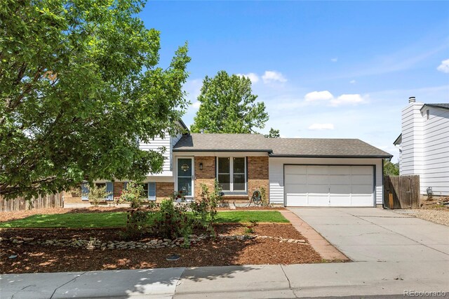 1153 S Biscay St, Aurora, CO 80017 - tri-level home with a garage, brick siding, and driveway