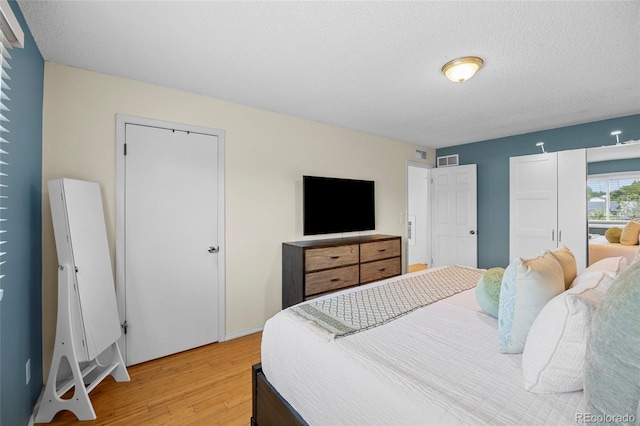 1153 S Biscay St, Aurora, CO 80017 - bedroom with light wood-style floors and a textured ceiling