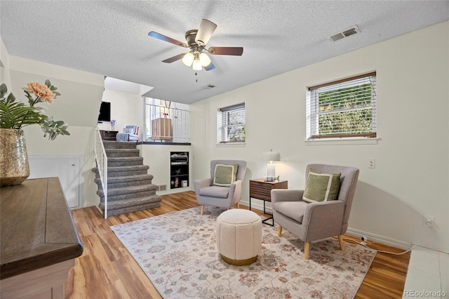 1153 S Biscay St, Aurora, CO 80017 - living room featuring light wood finished floors, ceiling fan, a textured ceiling, and baseboards
