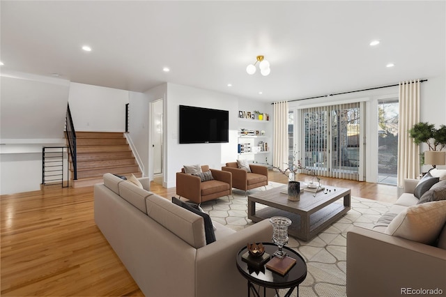 living area with light wood-style flooring, stairs, and recessed lighting