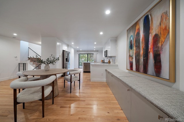 dining space with light wood-style flooring, stairs, baseboards, and recessed lighting