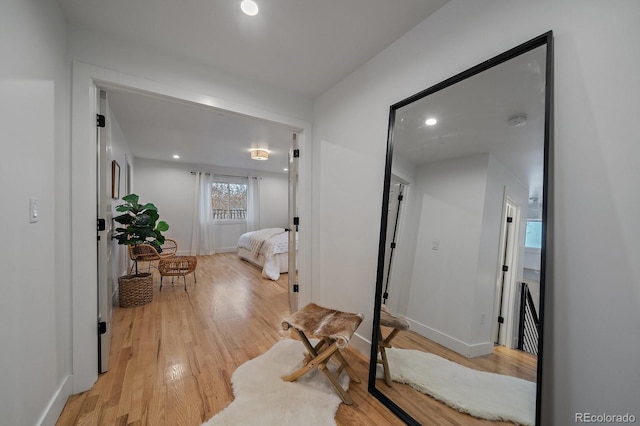 hallway with recessed lighting, baseboards, and light wood finished floors