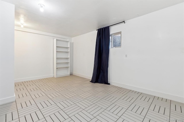 empty room featuring baseboards and light tile patterned floors