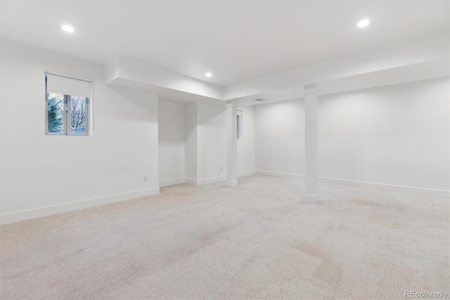 below grade area with baseboards, light colored carpet, and recessed lighting