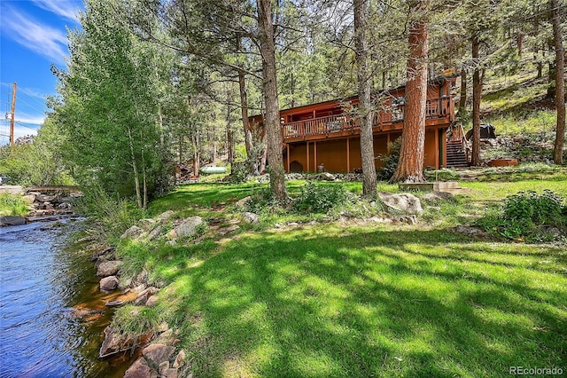 view of yard with a deck with water view