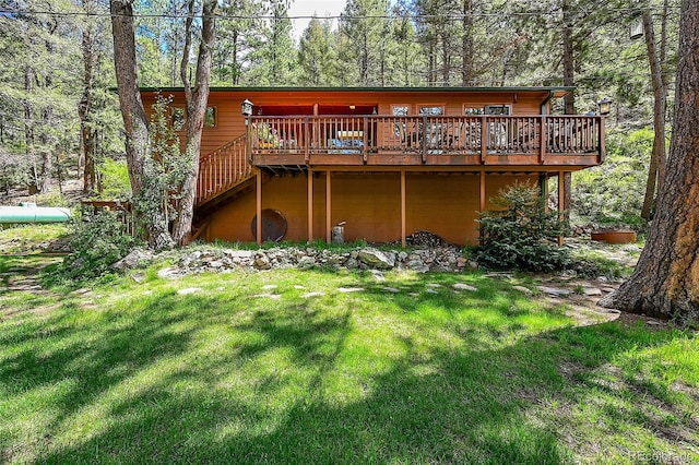 back of house featuring a wooden deck and a yard