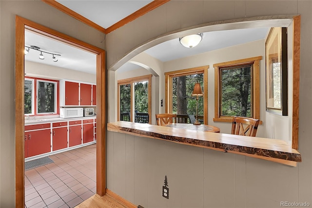 kitchen featuring tile patterned flooring, ornamental molding, track lighting, and sink