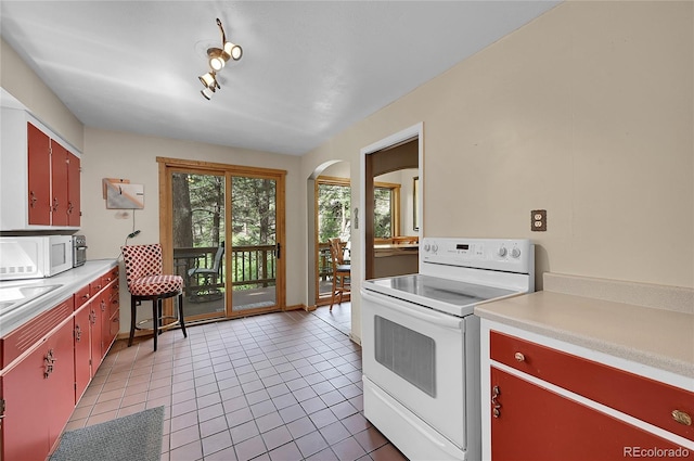 kitchen with rail lighting, light tile patterned flooring, and white appliances