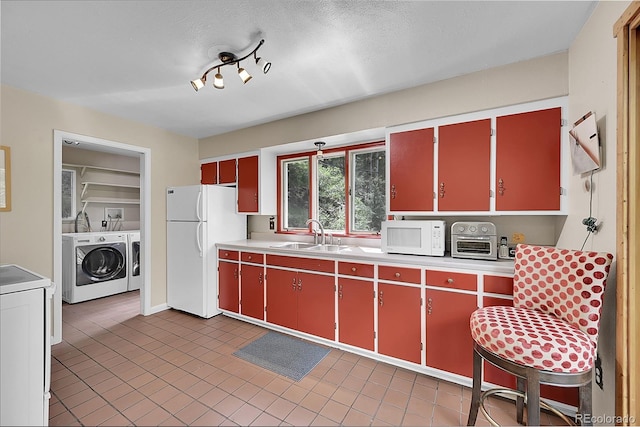 kitchen with sink, white appliances, light tile patterned flooring, and washer and dryer