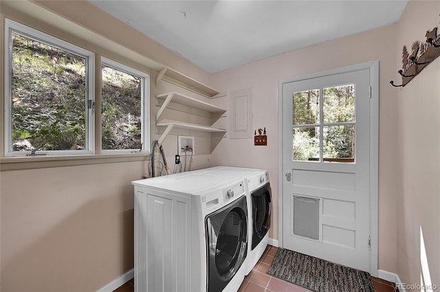 clothes washing area with dark tile patterned floors, plenty of natural light, and independent washer and dryer