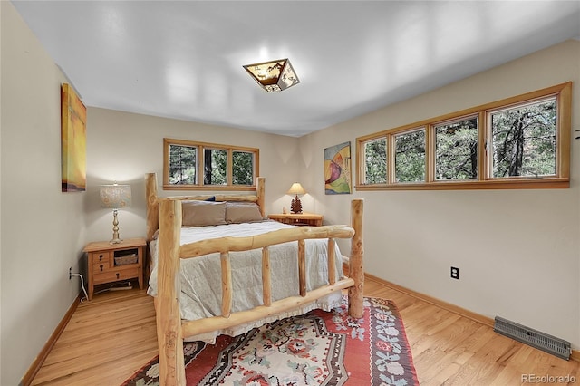 bedroom featuring light hardwood / wood-style flooring and multiple windows