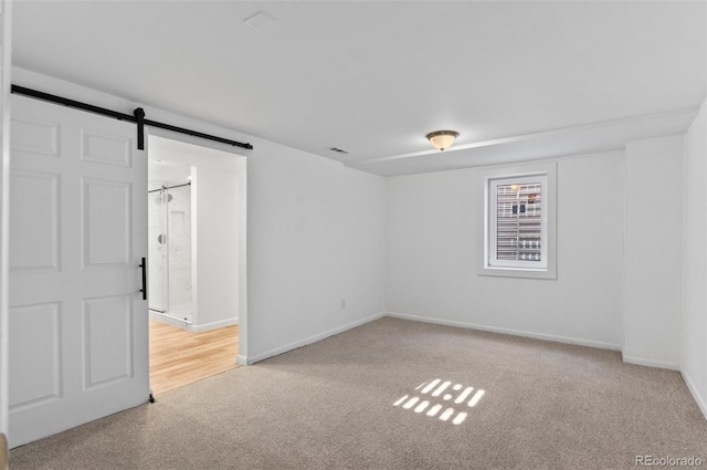 empty room with a barn door and carpet