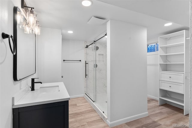 bathroom with vanity, a shower with shower door, and hardwood / wood-style floors