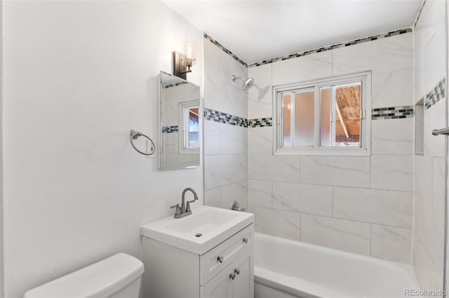 full bathroom with vanity, tiled shower / bath combo, and toilet