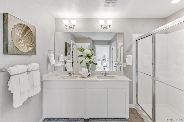 bathroom featuring vanity, a shower with shower door, and an inviting chandelier