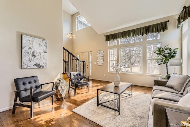 living room with a high ceiling, wood-type flooring, and a chandelier