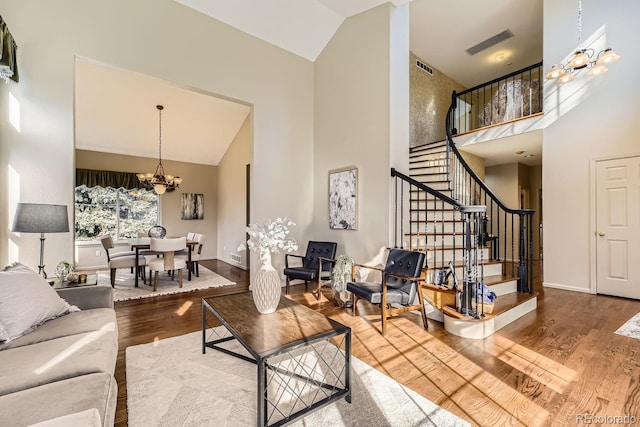 living room featuring high vaulted ceiling, hardwood / wood-style floors, and a chandelier