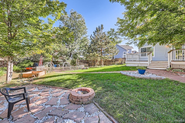 view of yard with a fire pit, a patio, and a deck