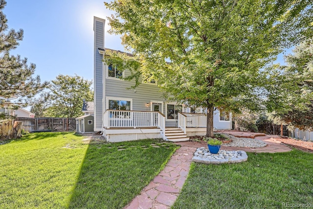 view of front of house with a storage unit, a deck, and a front lawn