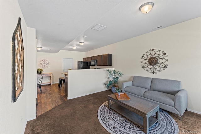 living room featuring dark carpet and baseboards