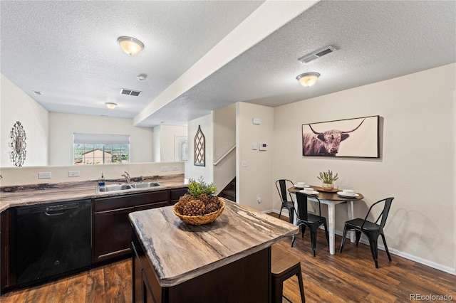 kitchen with black dishwasher, a sink, dark wood-type flooring, dark brown cabinets, and a textured ceiling