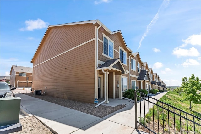view of side of home featuring a residential view and central AC