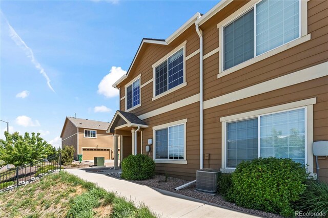 view of front of property with fence and central AC unit