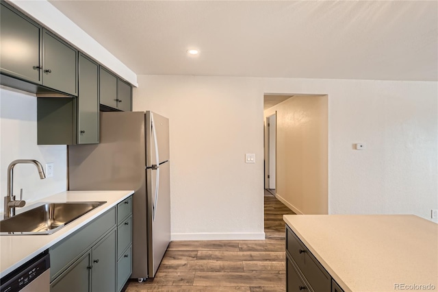 1302 S Parker Rd Unit 229, Denver, CO 80231 - kitchen featuring stainless steel dishwasher, a sink, wood finished floors, light countertops, and recessed lighting