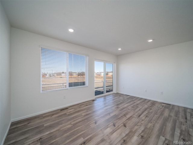 empty room featuring recessed lighting, visible vents, baseboards, and wood finished floors