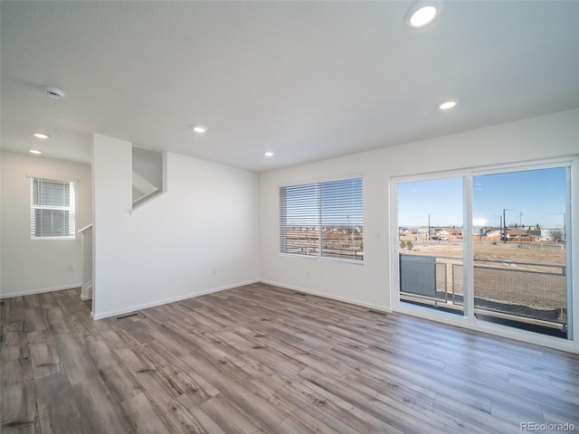 spare room featuring baseboards, wood finished floors, and recessed lighting