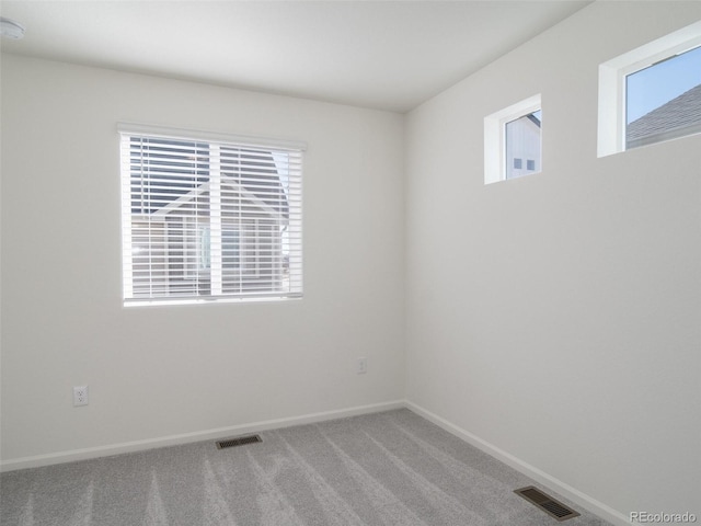 unfurnished room featuring carpet floors, baseboards, and visible vents