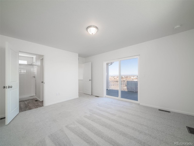 unfurnished bedroom featuring carpet floors, visible vents, ensuite bath, access to outside, and baseboards