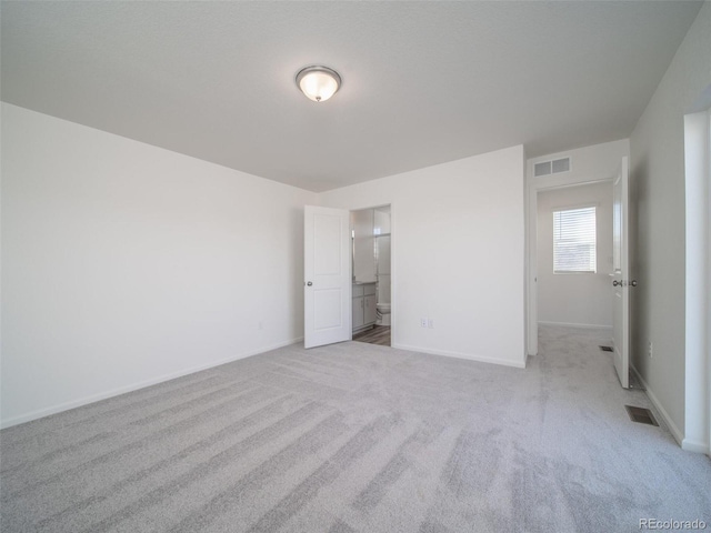 unfurnished bedroom with light colored carpet, visible vents, and baseboards