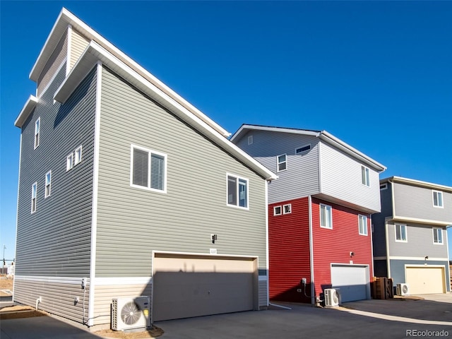 view of home's exterior featuring an attached garage and ac unit