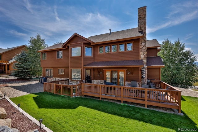 rear view of house with central AC unit, a deck, and a lawn