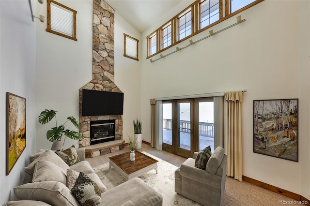 carpeted living room featuring plenty of natural light, a towering ceiling, and a fireplace